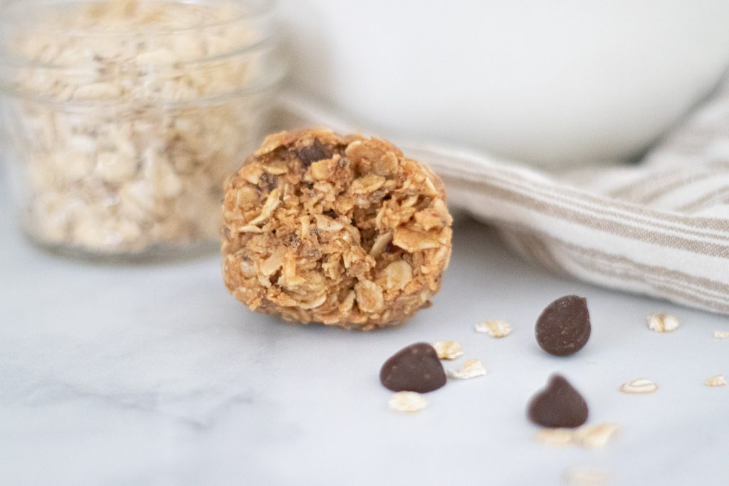 healthy peanut butter ball biten into with chocolate chips showing