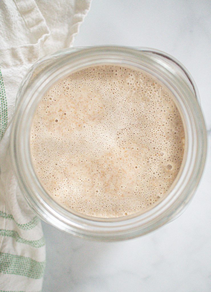 bubbly sourdough starter in glass jar alive and active