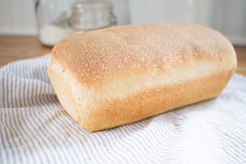 golden soft sourdough sandwich bread on tea towel