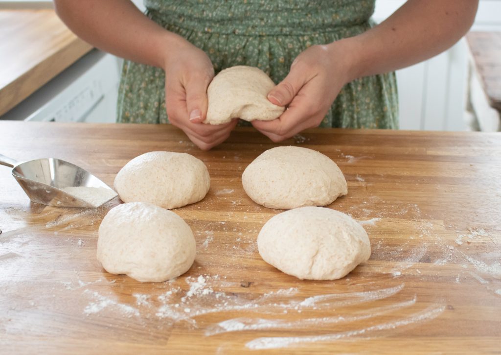 lady shaping bagel dough
