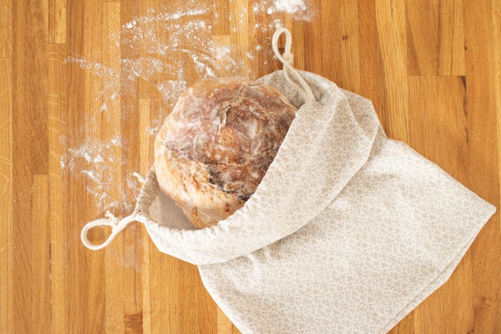 bread sticking out of bread bag on wooden counter top