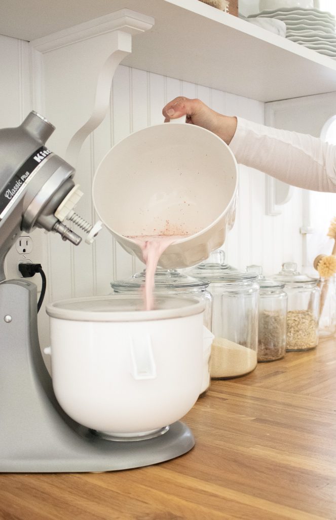 strawberry ice cream batter being poured into ice cream maker