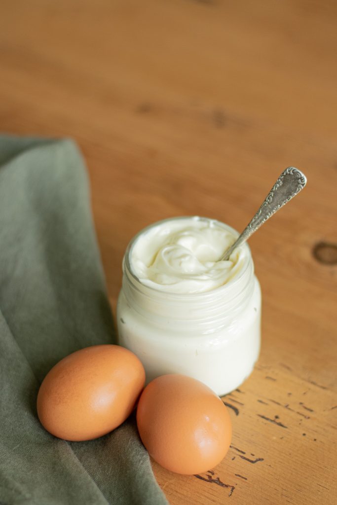 homemade mayo in glass jar with butter spreader utensil 
