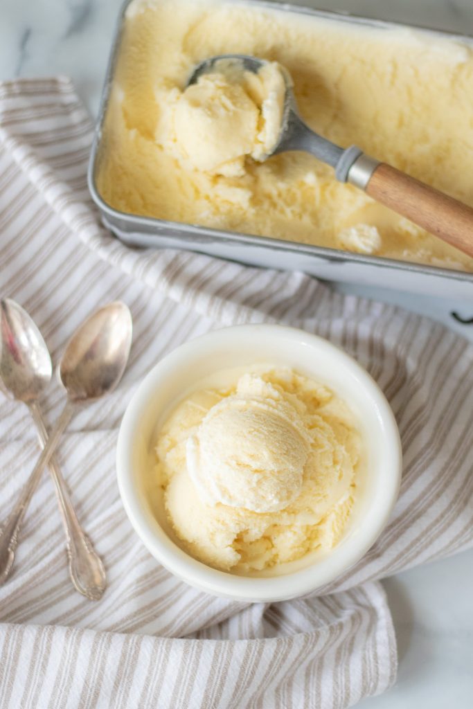 Creamy Raw Milk Vanilla Ice Cream in white bowl sitting on top of marble counter top 